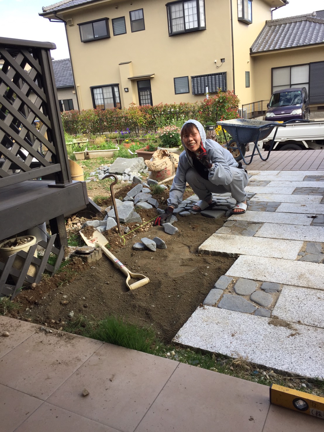 DIYで玄関アプローチを製作している途中段階の写真。地面に石が部分的に並べられている様子。