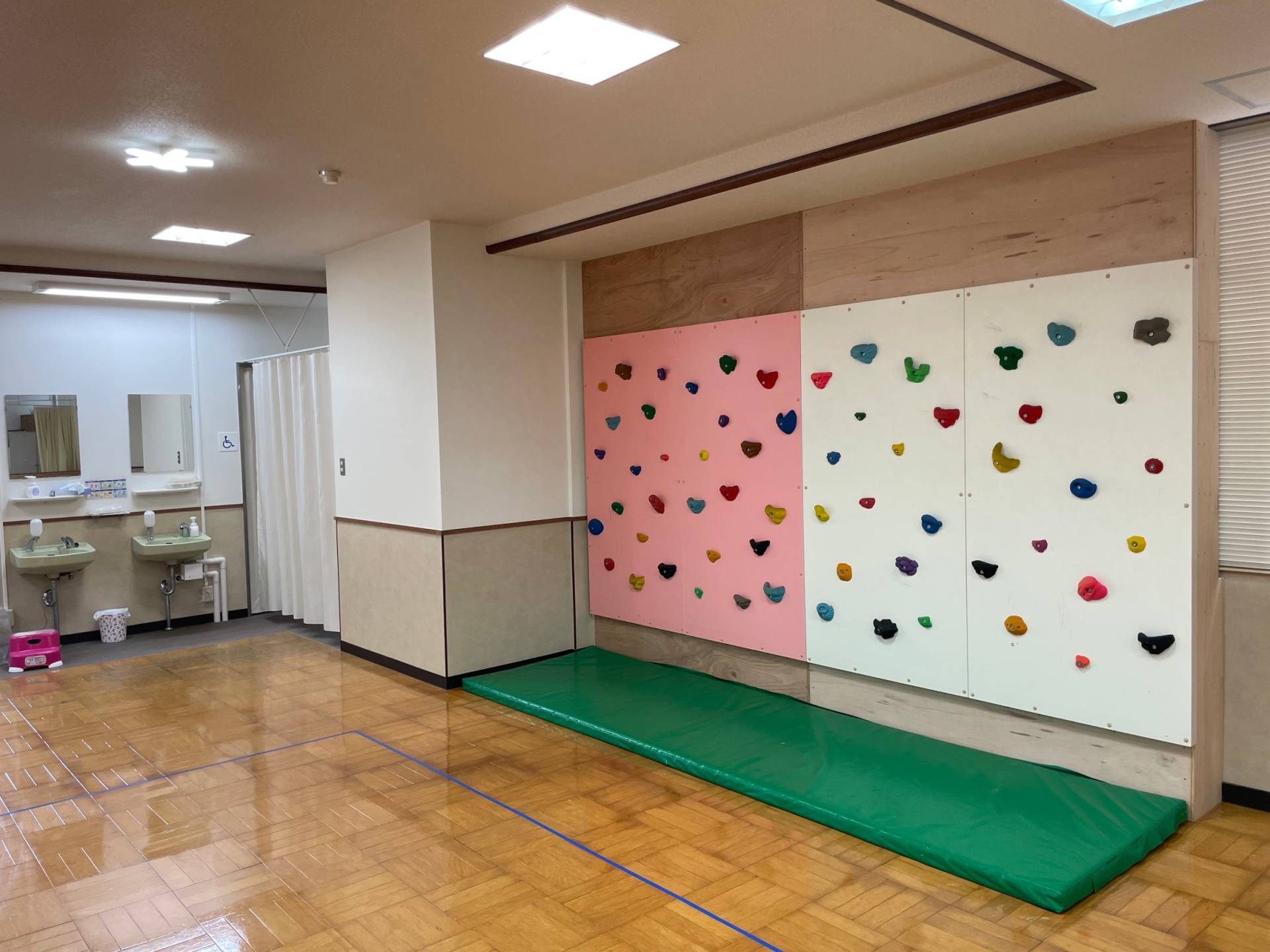 設置されたボルダリングウォール。カラフルなホールドが並ぶ子ども用遊具。