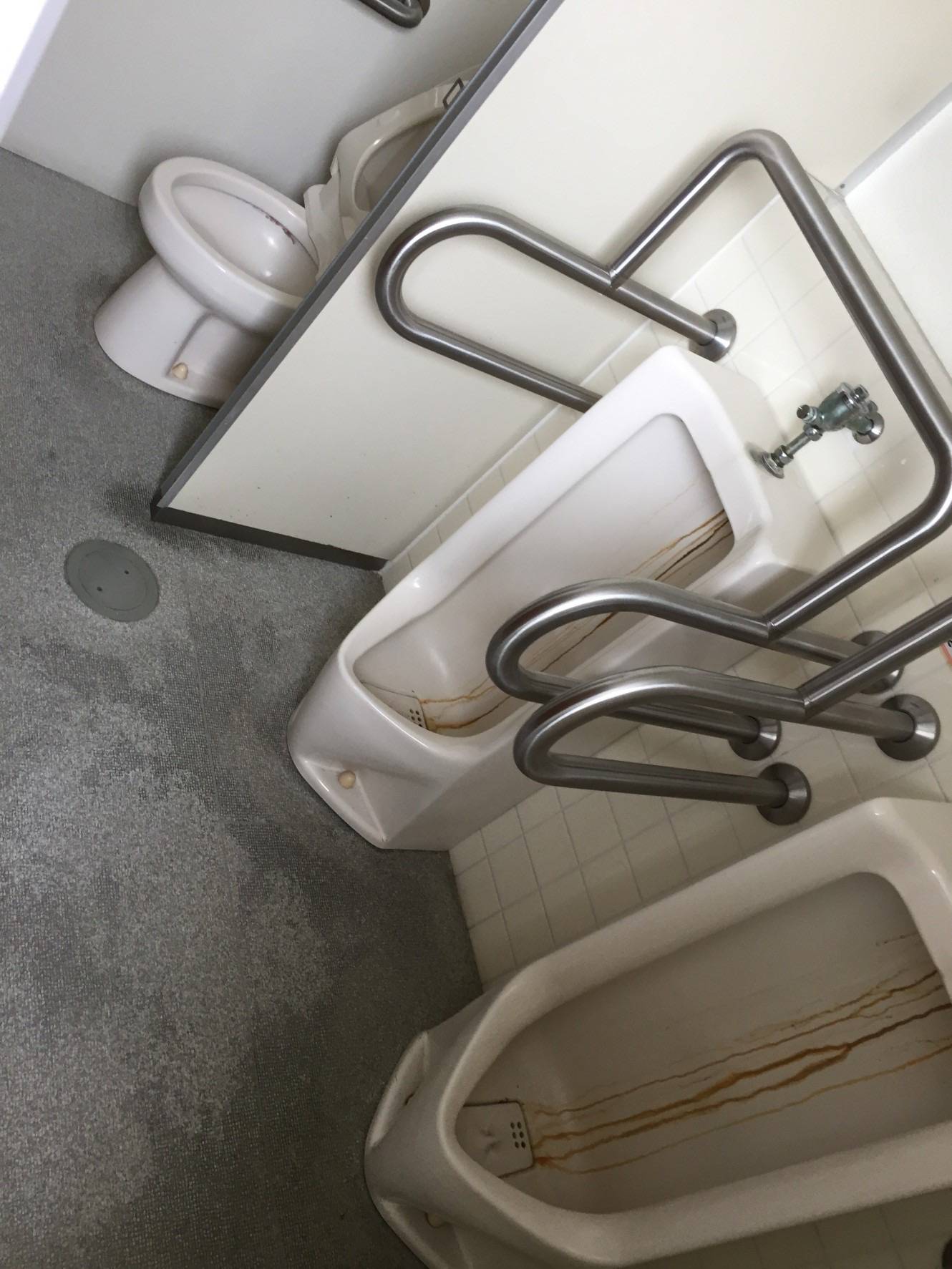清掃前のトイレ。壁面や床に汚れが蓄積している。
