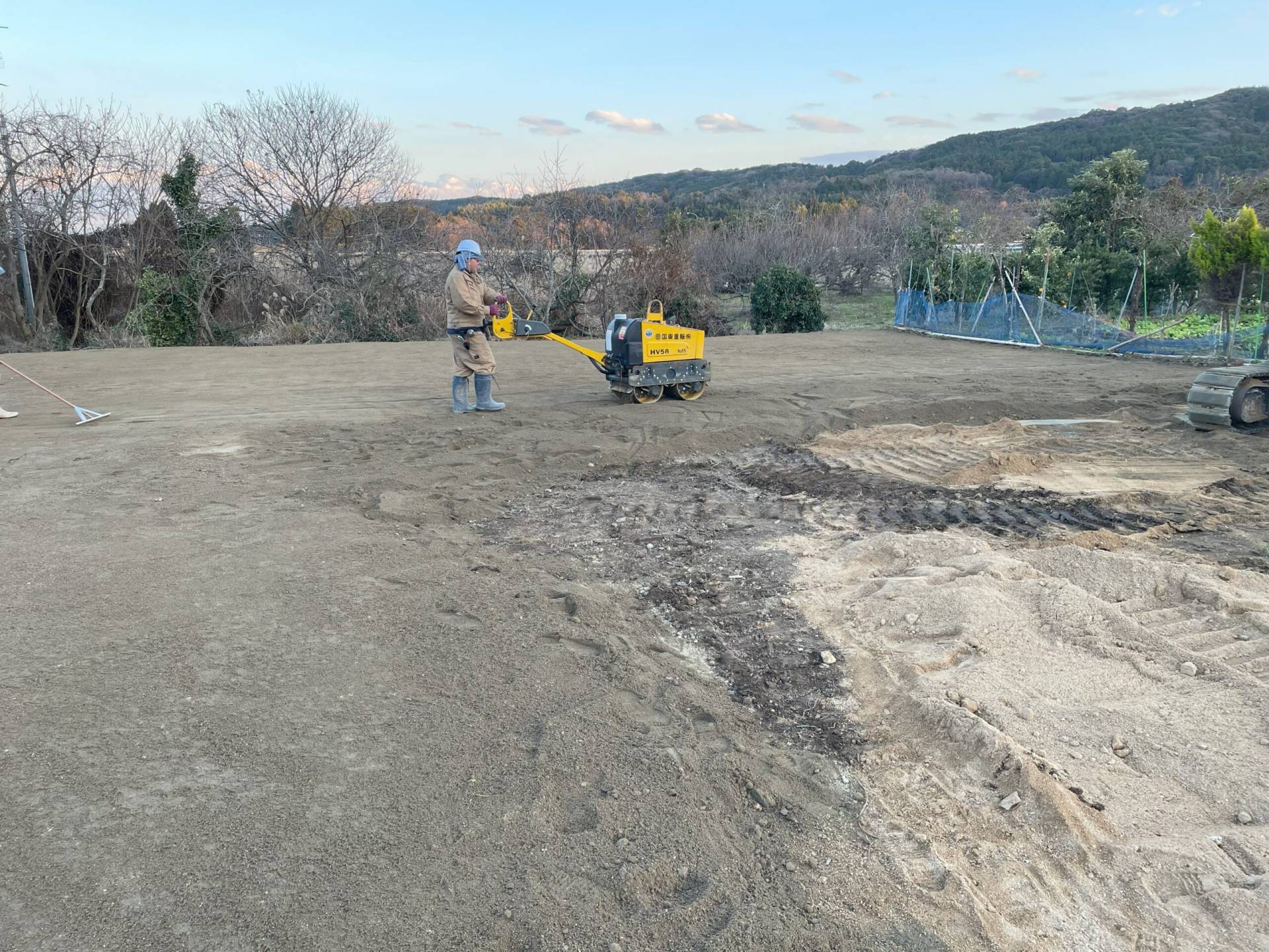 国東市で真砂土舗装中の風景。施工スタッフが転圧機で平らに整えている様子