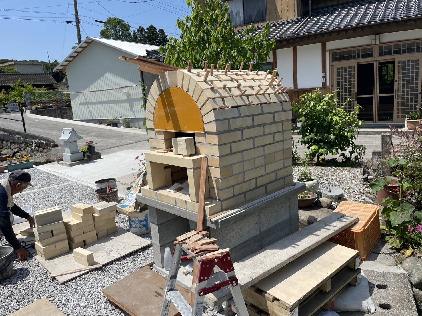 国東市で建設中のピザ窯。窯の入り口部分の美しいアーチと、上部に伸びる煙突が耐火レンガで作られている写真。熱効率の高い設計。